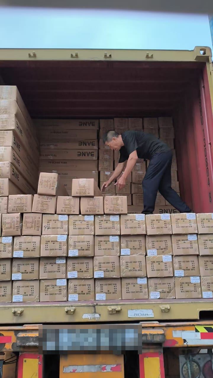 工人在敞开的集装箱内码放贴有标签的纸箱